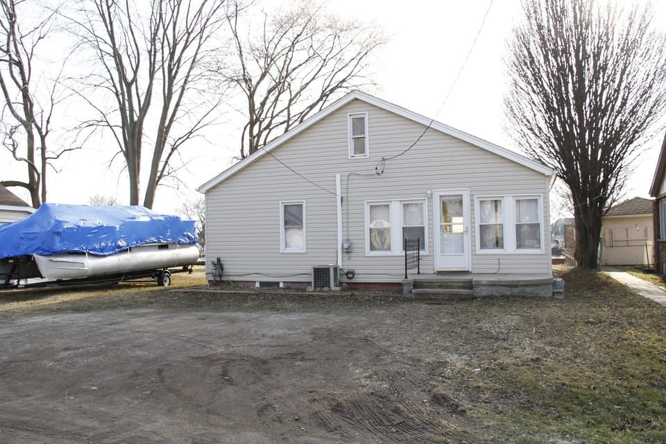 back of house and driveway with ample parking