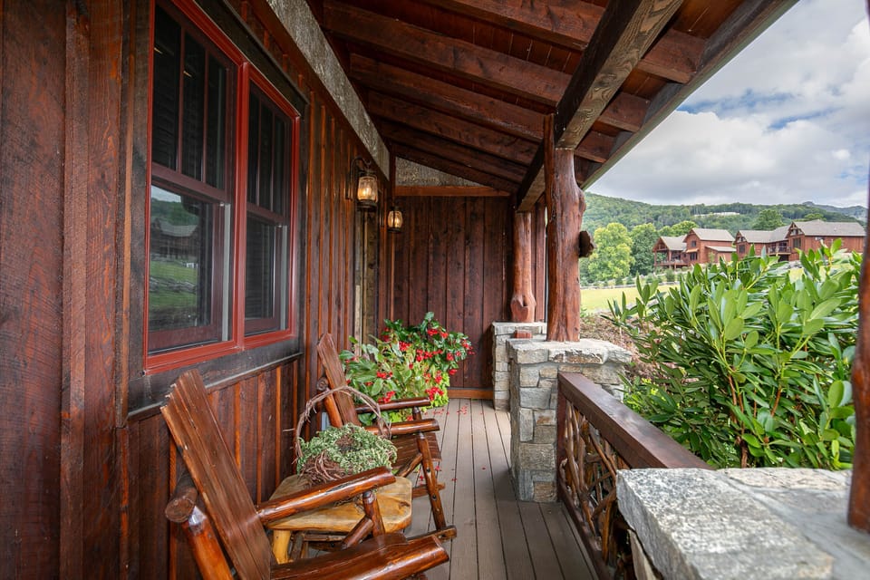 Settle into a rustic log rocker and take in the Blue Ridge views from the covered porch at Prancing Horse Lodge At Eagles Nest.