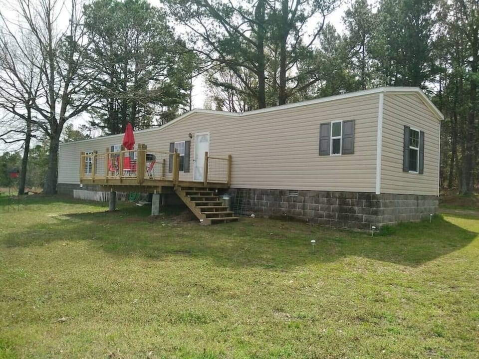 Large front deck with charcoal grill, table, and chairs