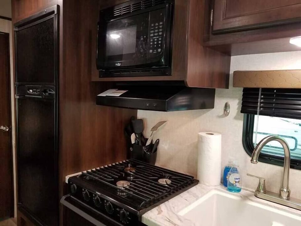 Kitchen is stocked with cooking utensils and serviceware. 