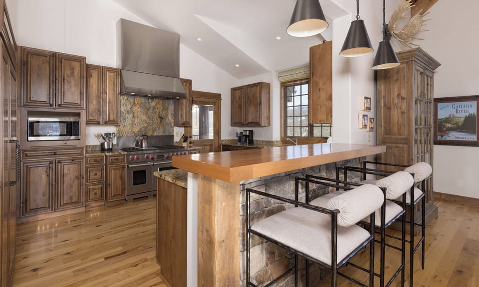 Your gourmet kitchen features rich wood cabinetry, granite countertops, and a spacious island perfect for cooking memorable meals together.