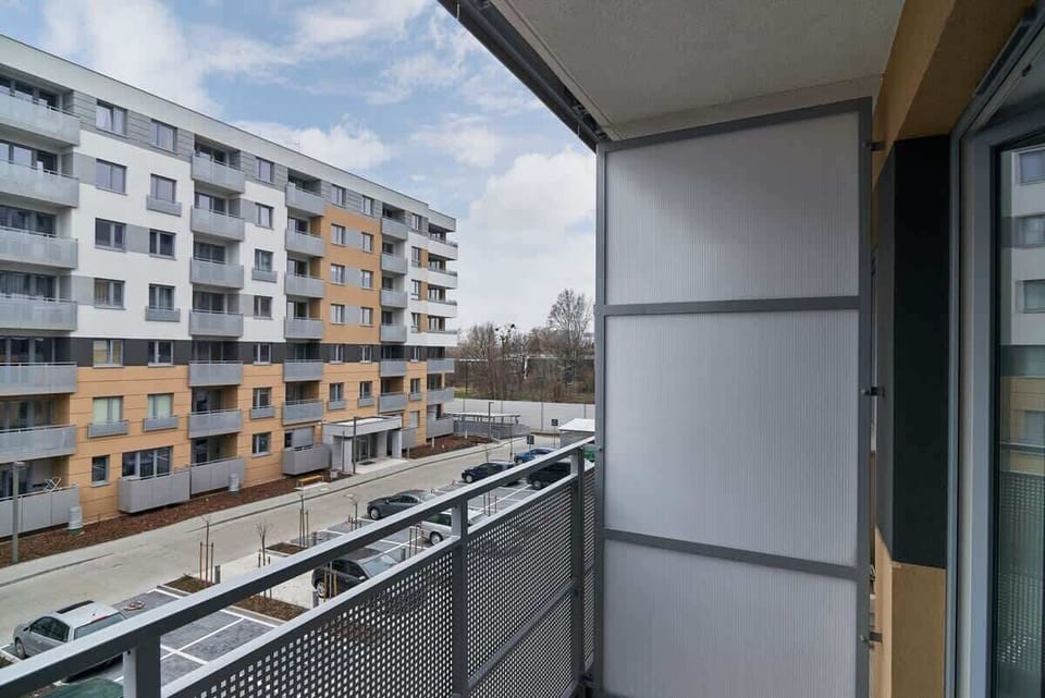 A balcony with a railing overlooking neighboring modern apartment buildings.