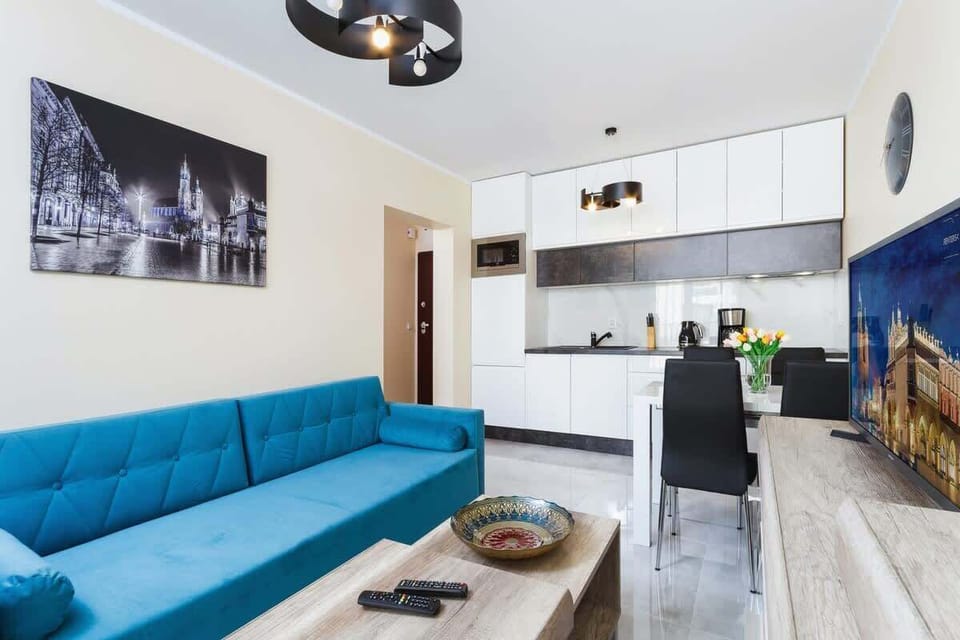 Living area, showing the sofa, dining table, and the kitchen in the background.