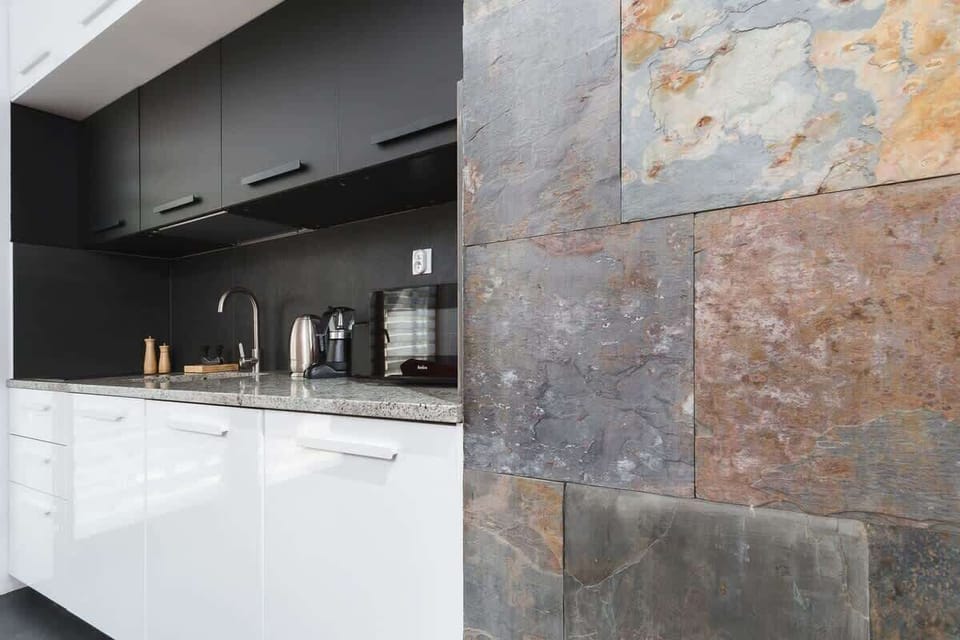 A wide-angle view of the kitchen highlighting ample storage, clean white countertops, and a minimalist design aesthetic.