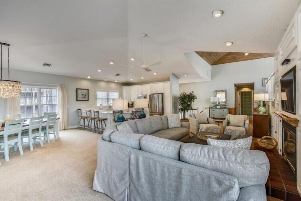 Unwind in your spacious open-concept living area, where natural light floods through large windows and vaulted ceilings create an airy, welcoming atmosphere for gathering and relaxing together.