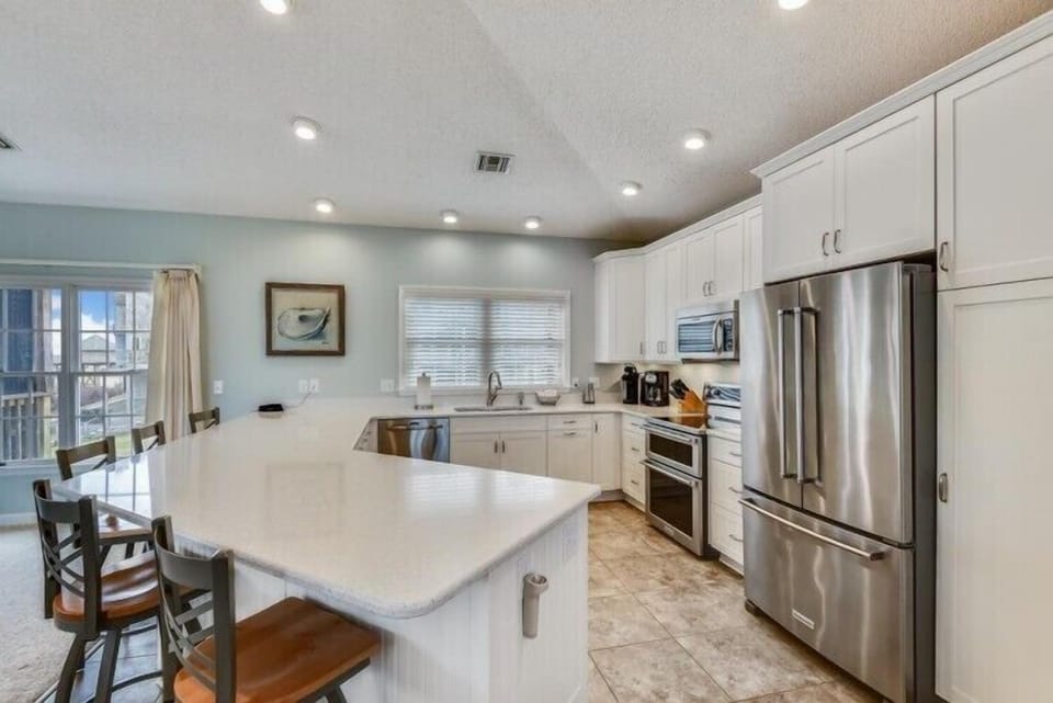 Prepare meals together in this bright, fully equipped kitchen with stainless appliances, ample counter space, and a convenient island for morning coffee or evening appetizers.