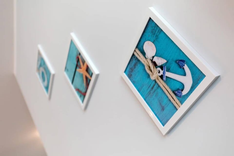 Hanging on the wall are pictures in white frames with a marine design. 
