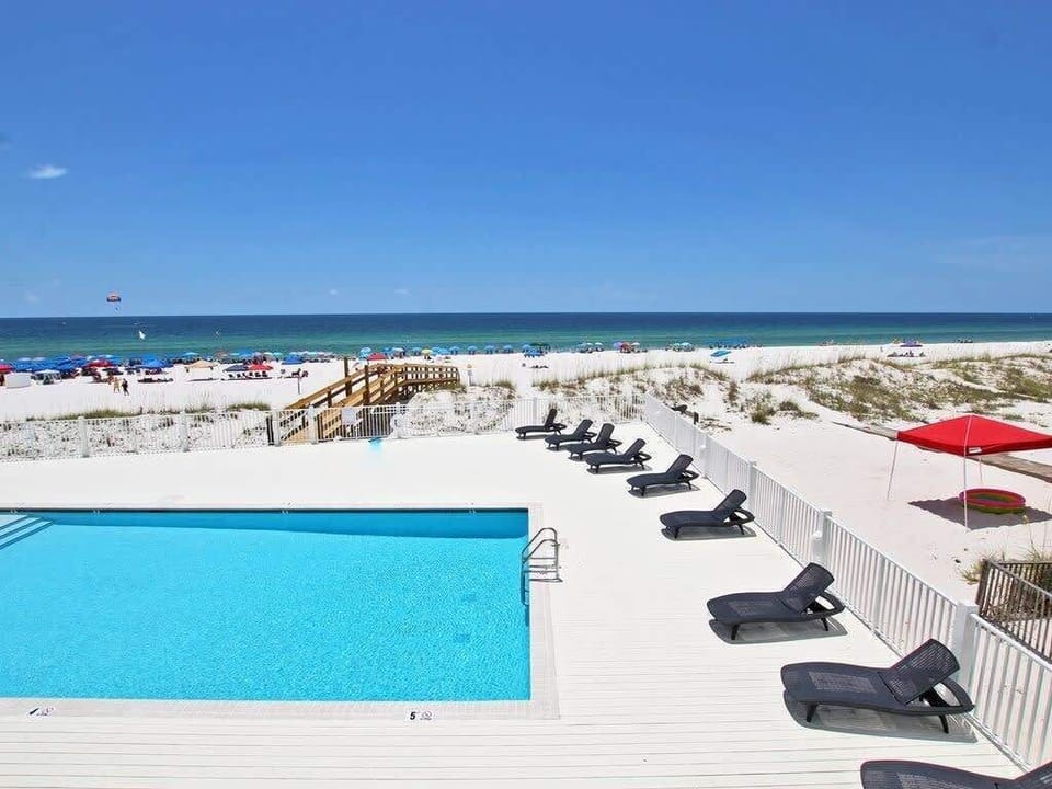 Beach-side pool with spacious sundeck and loungers. 