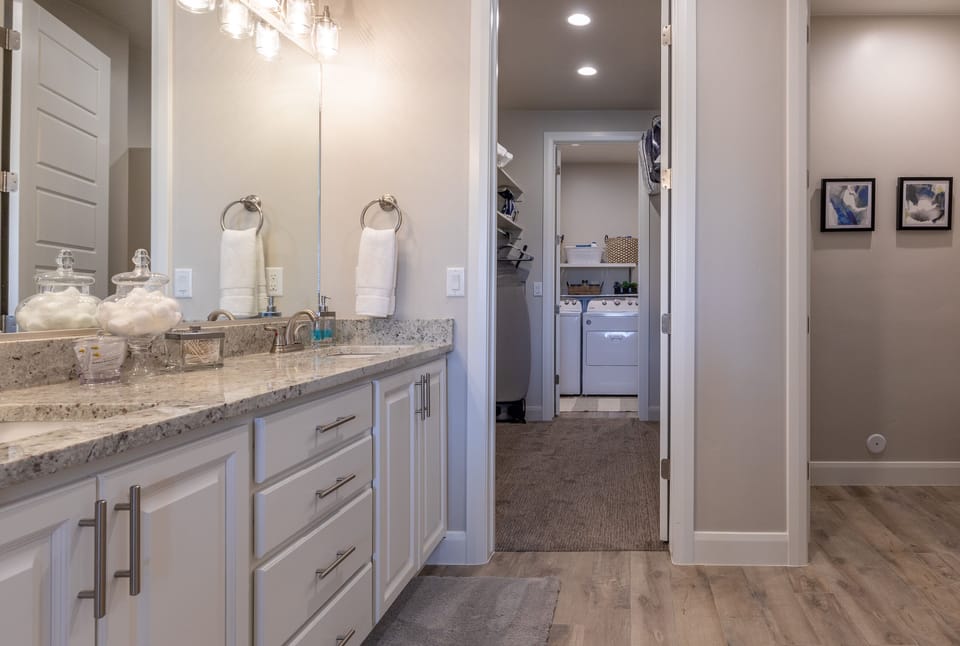 Main Bathroom Vanity - The Main bathroom that is adjacent to the master bedroom is large and luxurious. With his and her sinks, toilet, vanity, walk-in shower, large bathtub and a large walk-in closet.