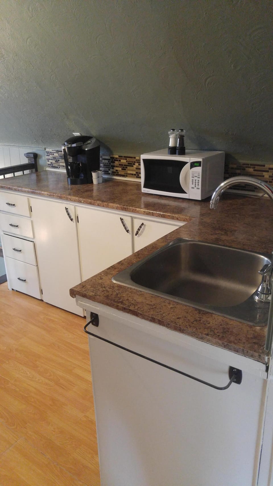 Kitchen has a microwave, coffee machine, fridge, stove, and kettle