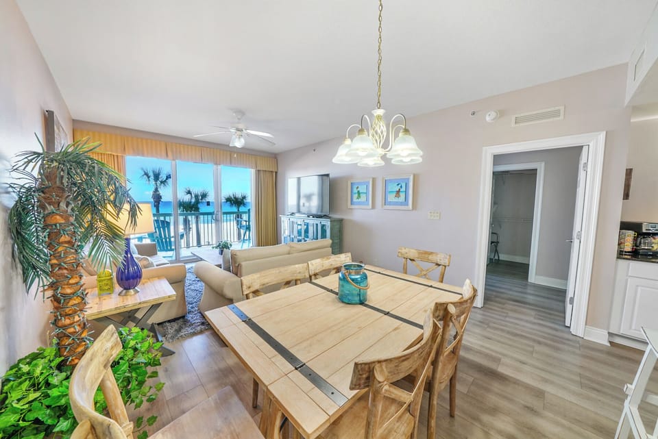 Gather around your spacious dining table while enjoying stunning ocean views through floor-to-ceiling windows in this bright, coastal-inspired living space.