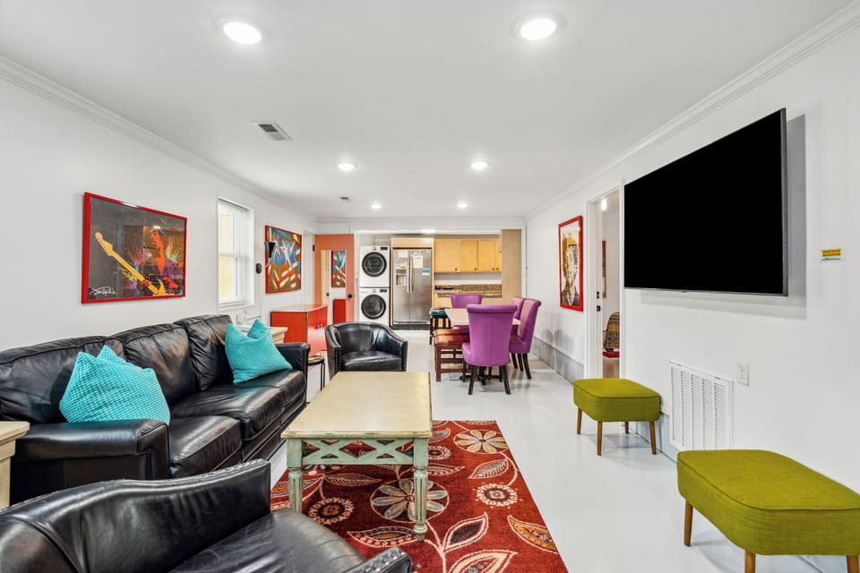 Open floor plan with comfortable furniture including a queen size sleeper sofa and a flat screen TV.