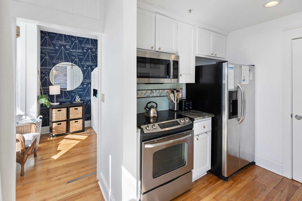 Your coastal-inspired kitchen features stainless steel appliances and bright white cabinets, perfect for preparing meals during your stay.