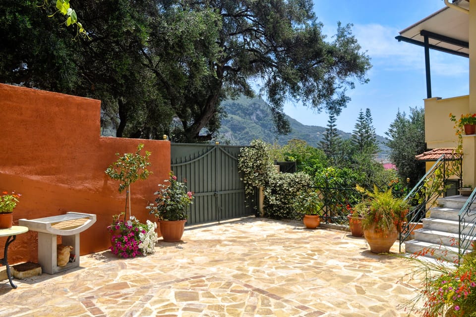 Private entrance with many flowers and barbecue area.