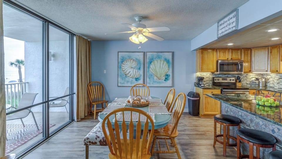 Enjoy meals in your bright dining area with ocean-themed art while the coastal breeze flows from your private balcony.