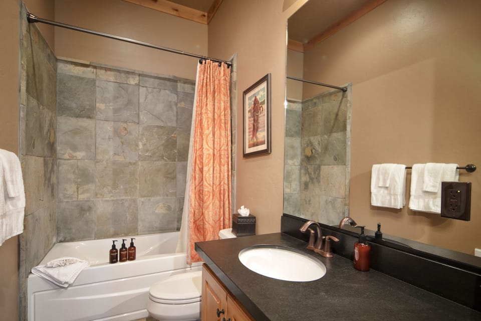 Unwind in your spacious bathroom featuring natural stone tile work and warm earth tones that create a spa-like retreat after your mountain adventures.