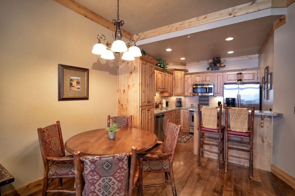 Your mountain retreat awaits with warm wood accents and rustic charm. Cook your favorite meals in the fully equipped kitchen, then gather around the handcrafted dining table for memorable conversations under the cozy chandelier light.