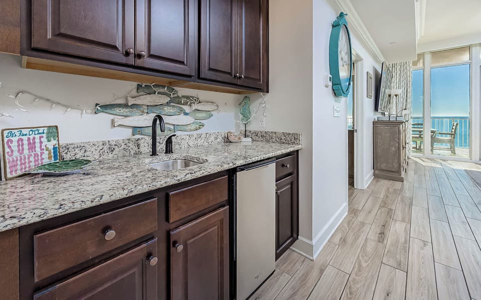 Grab a chilled drink from the fridge or create your favorite cocktail at the wet bar with fun coastal accents