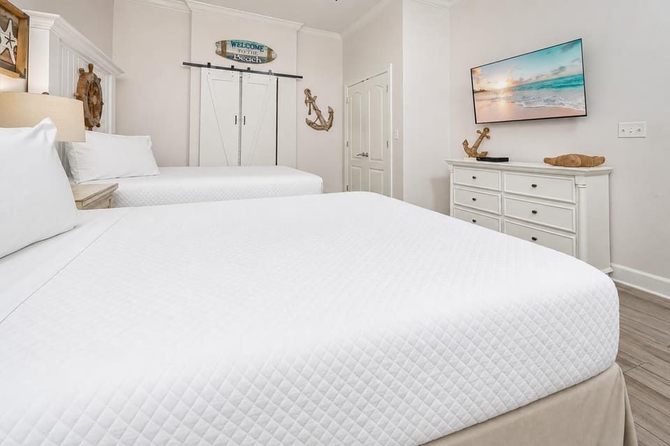 Drift off to sleep in this queen guest bedroom, where soft bedding and coastal decor create a serene atmosphere