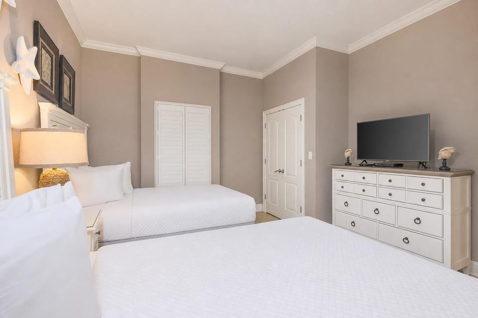 Rejuvenate in this guest bedroom with two queens inviting restful nights and joyful mornings
