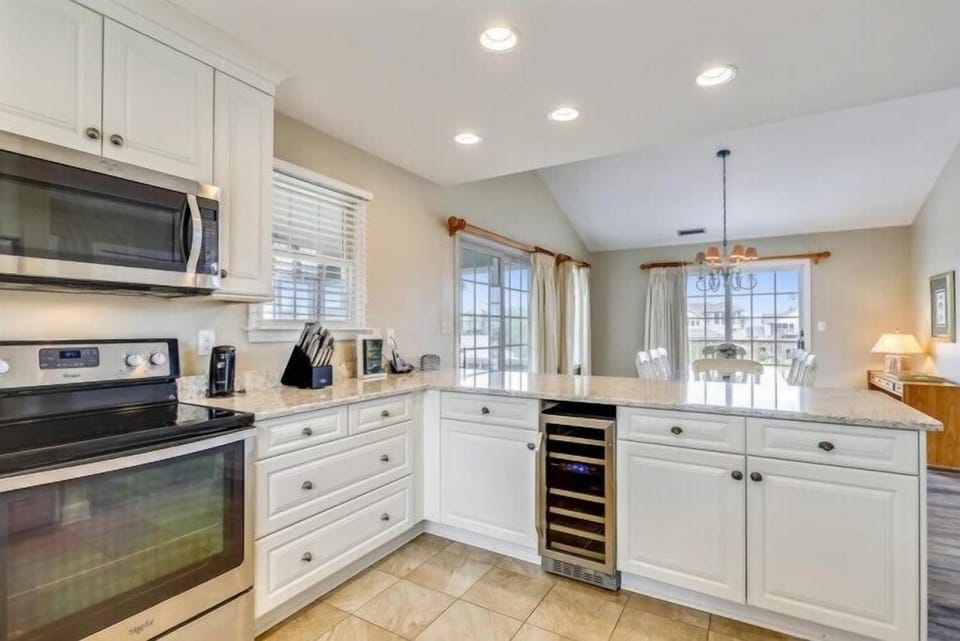 You'll love preparing meals in this bright, fully equipped kitchen with modern appliances, generous counter space, and a warm open layout that flows seamlessly into the dining area.