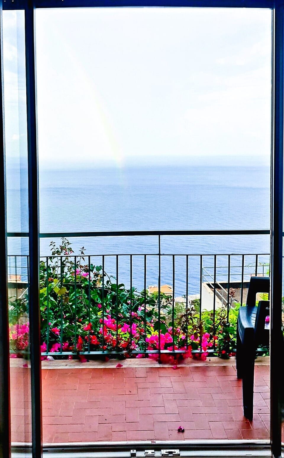 Panorama mozzafiato dal balcone di casa con uno splendido arcobaleno