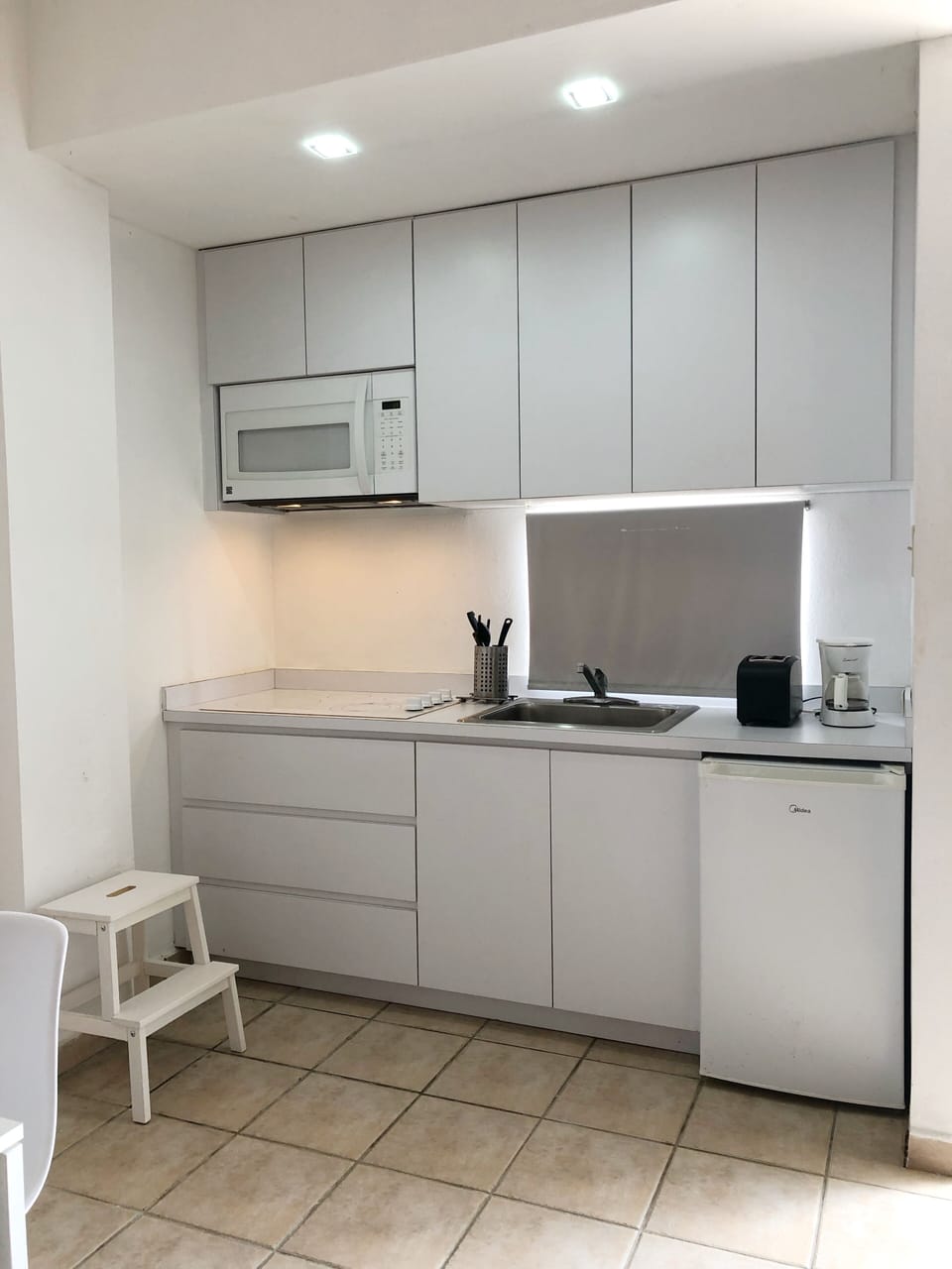 Cocina equipada con los utensilios básicos, tostadora, estufa, cafetera y otros.