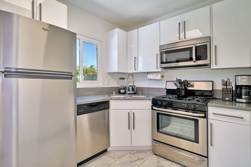 Kitchen with gas range, dishwasher and exit to private backyard. 