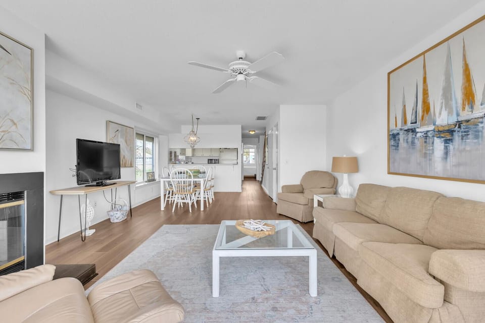 Unwind in your bright, open living space with coastal artwork and cozy seating for relaxing evenings.
