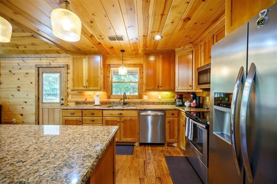 Whip up your favorite meals in this fully equipped kitchen with modern stainless appliances, granite countertops, and warm wood finishes throughout.