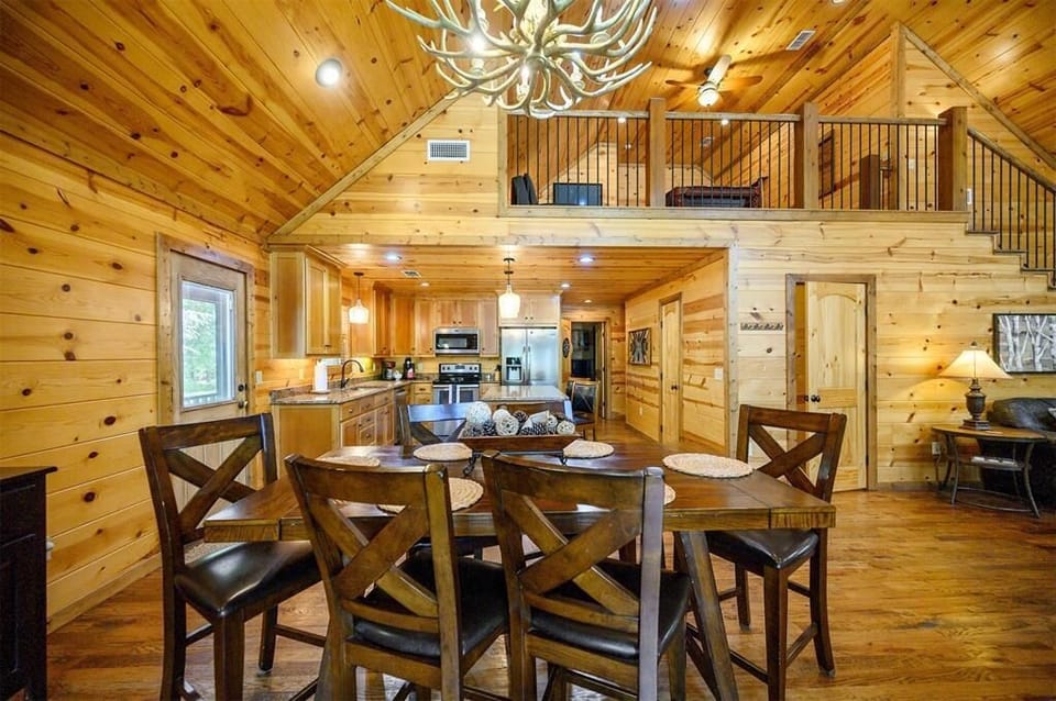 Step into rustic elegance with soaring wood ceilings and a dramatic antler chandelier. Your open-concept space flows from a fully equipped kitchen to a welcoming dining area—perfect for gathering after a day of adventure.