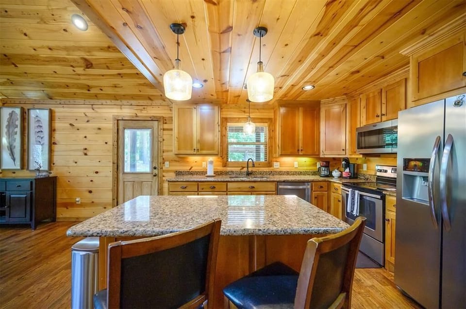Gather around your spacious granite island in this beautifully crafted kitchen, where warm wood tones and modern appliances blend perfectly for memorable meal prep and family time.