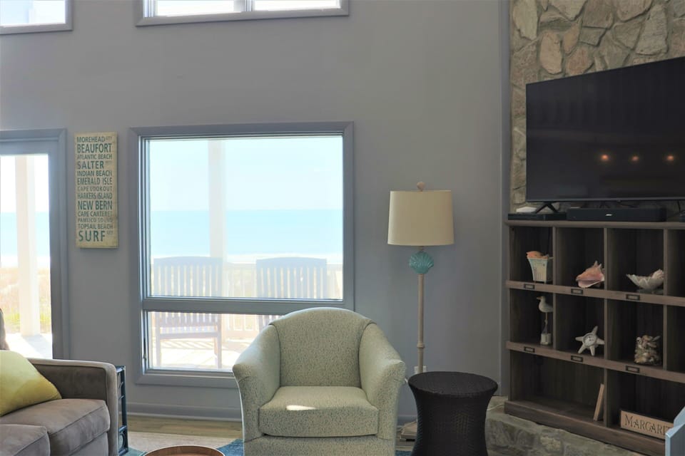 Unwind in your coastal retreat with ocean views, stone fireplace, and beach-themed decor creating the perfect seaside sanctuary.