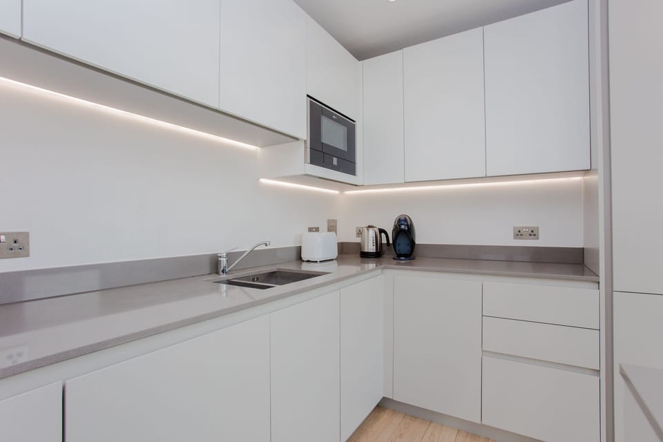 Open plan kitchen with dishwasher, freezer, fridge, microwave and oven