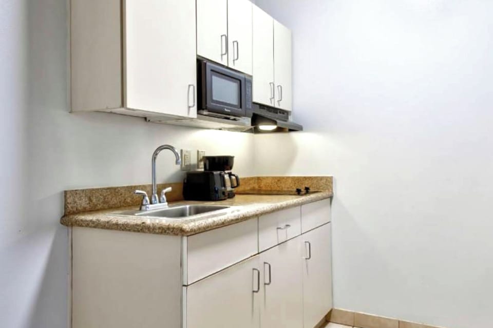 Coffee/tea maker, fridge, microwave, dining table