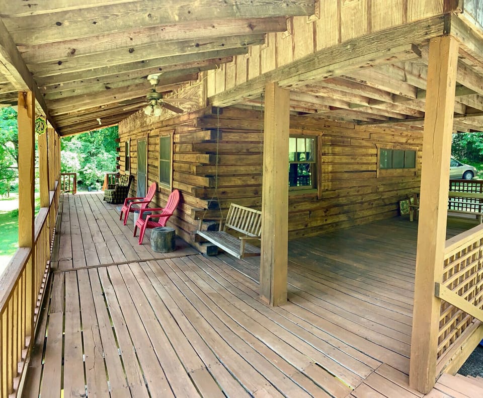 Large covered porch with chairs, swing, and table