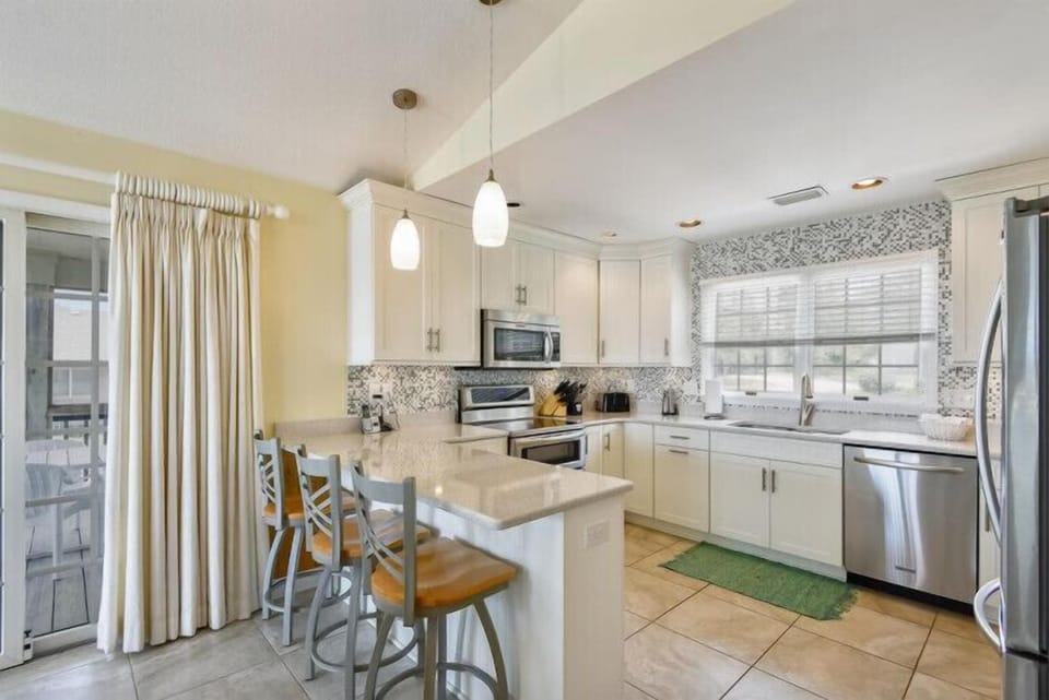 Your bright, airy kitchen awaits with gleaming countertops, modern appliances, and breakfast bar seating—perfect for preparing meals and gathering with loved ones.