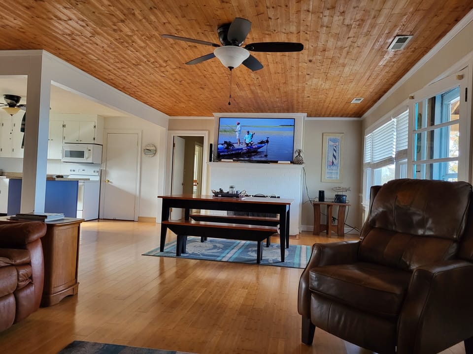 Large living room with reclining leather furniture and 65" Smart TV