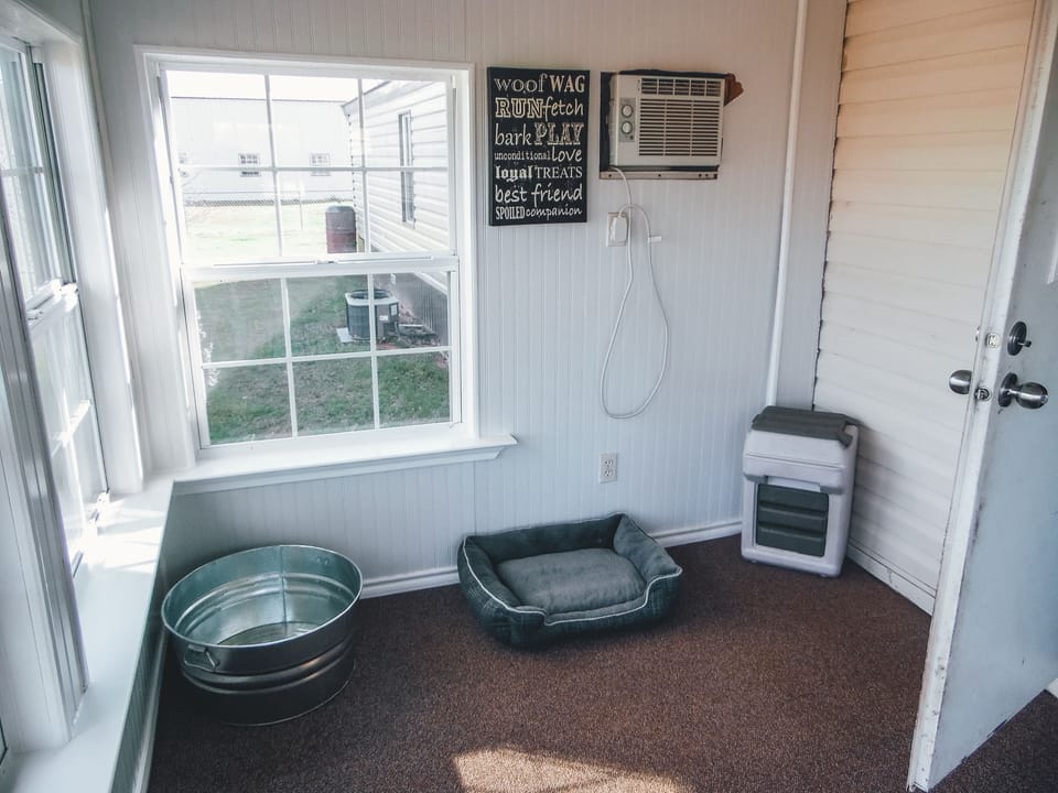 Dog room with separate air conditioning window unit.