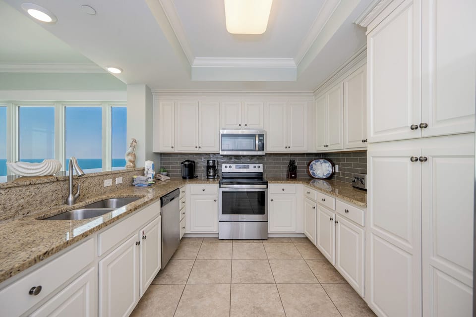 Experience culinary delight as you prepare meals with stunning coast views brightening the inviting kitchen space
