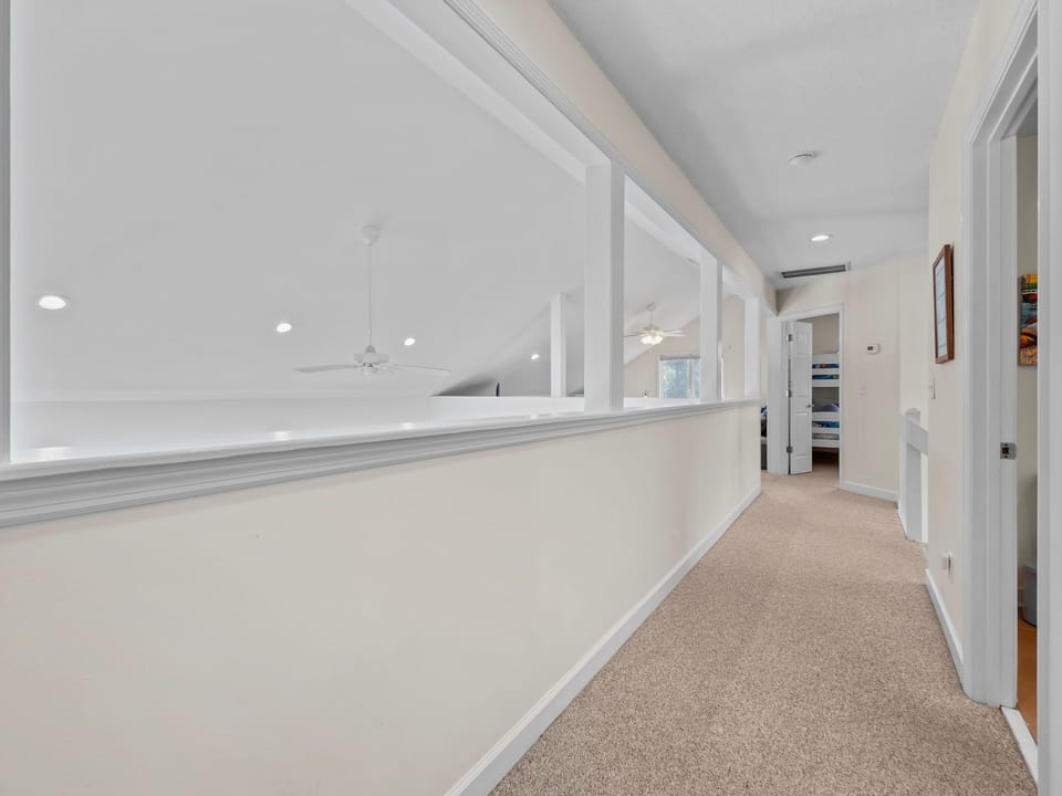 Walk through your bright, airy hallway with elegant white walls and soft carpeting beneath your feet.