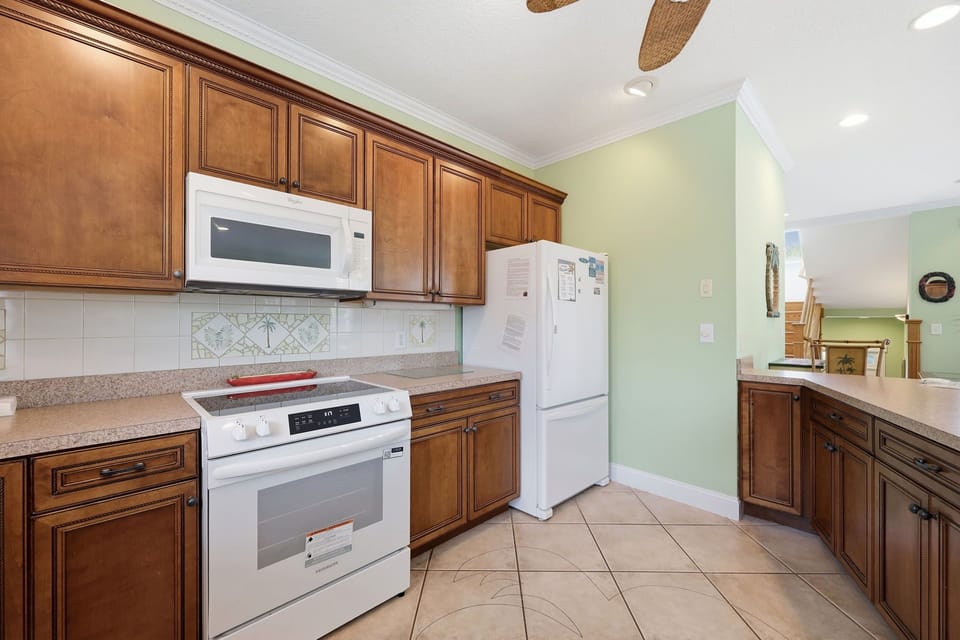 Your kitchen awaits with warm wood cabinetry, modern appliances, and spacious counters—perfect for preparing meals and gathering with loved ones during your stay.