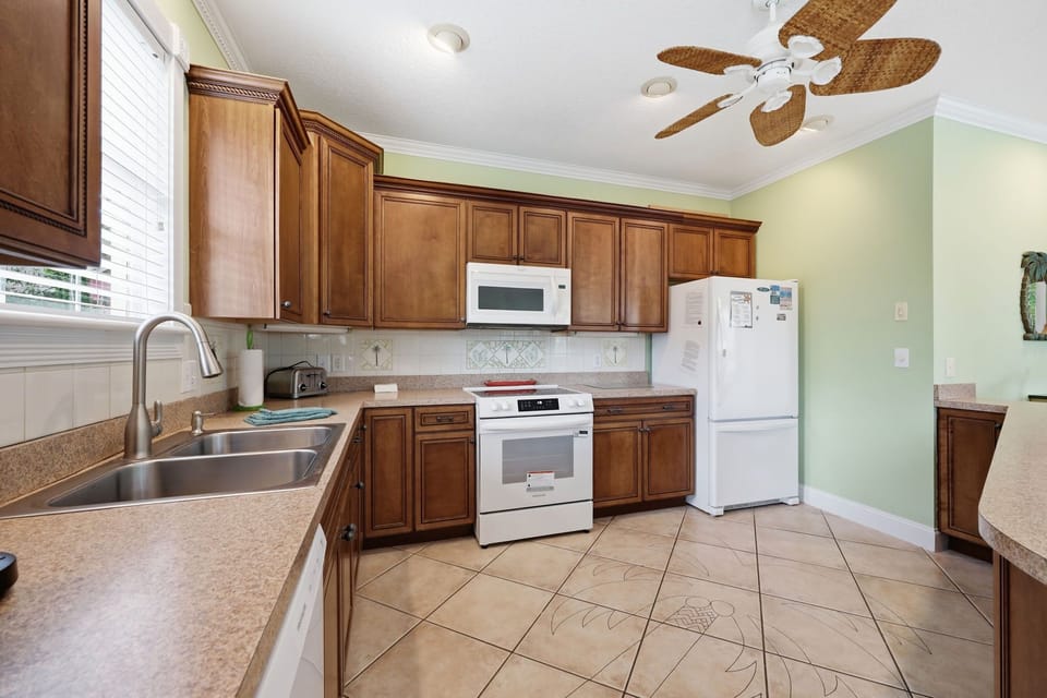 Your fully equipped kitchen features warm wood cabinetry, modern appliances, and ample counter space—perfect for whipping up meals between beach adventures.