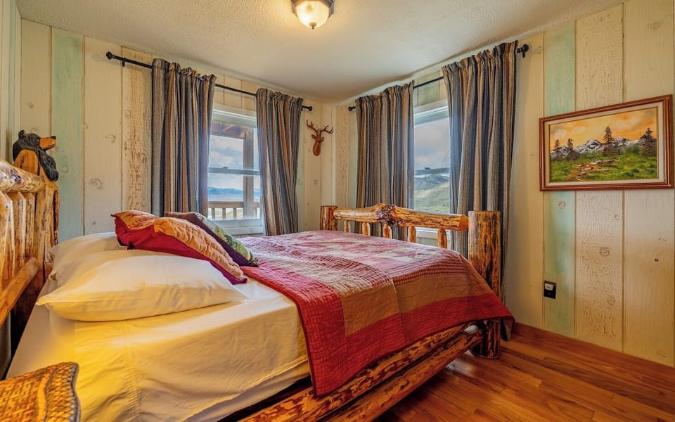 Main level bedroom features a Queen bed with lodgepole frame