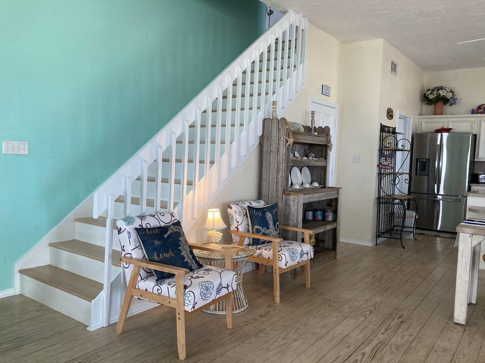 Staircase to master suit from living room. Comfy chairs to watch waves! 
