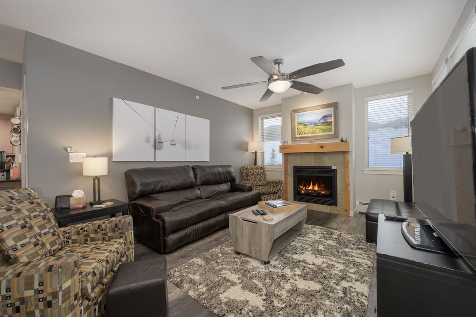 Large living space with fireplace and cozy leather couch