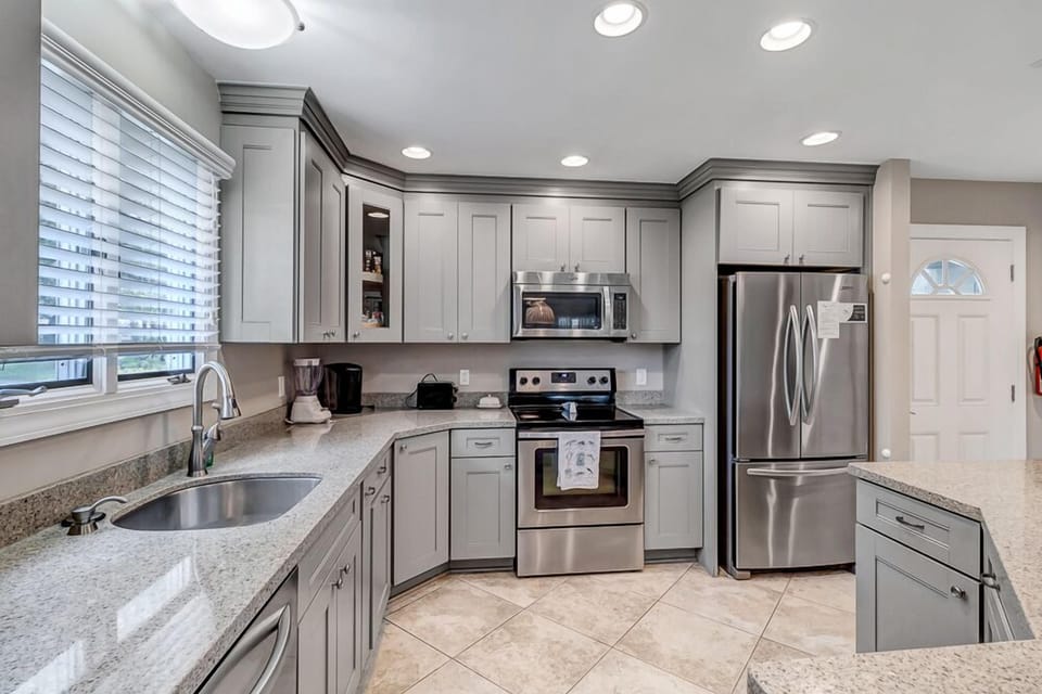 - Spacious kitchen with wraparound counters, stainless steel appliances, and modern finishes
- Large window above sink offers natural light while prepping meals or snacks
- Thoughtfully designed with plenty of cabinetry for easy storage