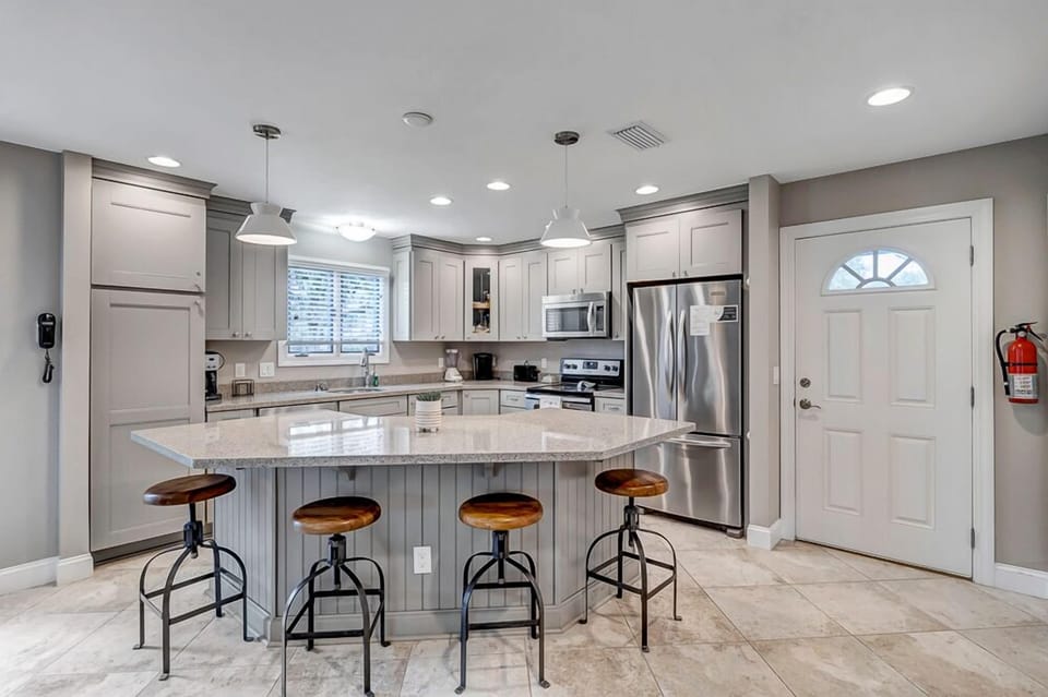 - Large granite island with bar seating for four, ideal for casual dining or morning coffee
- Stainless steel appliances and soft gray cabinetry offer a sleek, cohesive look
- Pendant and recessed lighting brighten every culinary moment