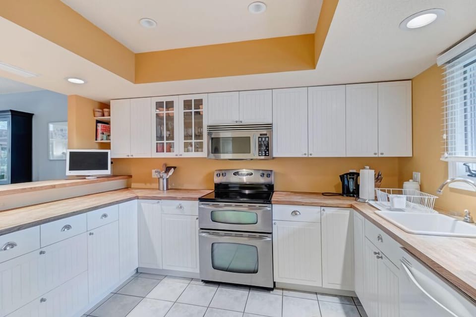 - U shaped kitchen layout features breakfast bar seating and sunny views
- All the essentials are here, including coffee maker, toaster, and cookware
- Crisp design with bright lighting, perfect for family meals and snacks