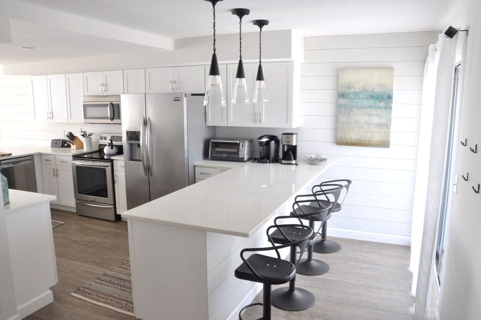 Extended quartz counter tops with metal bar stools - 4 on each side, seating 8  